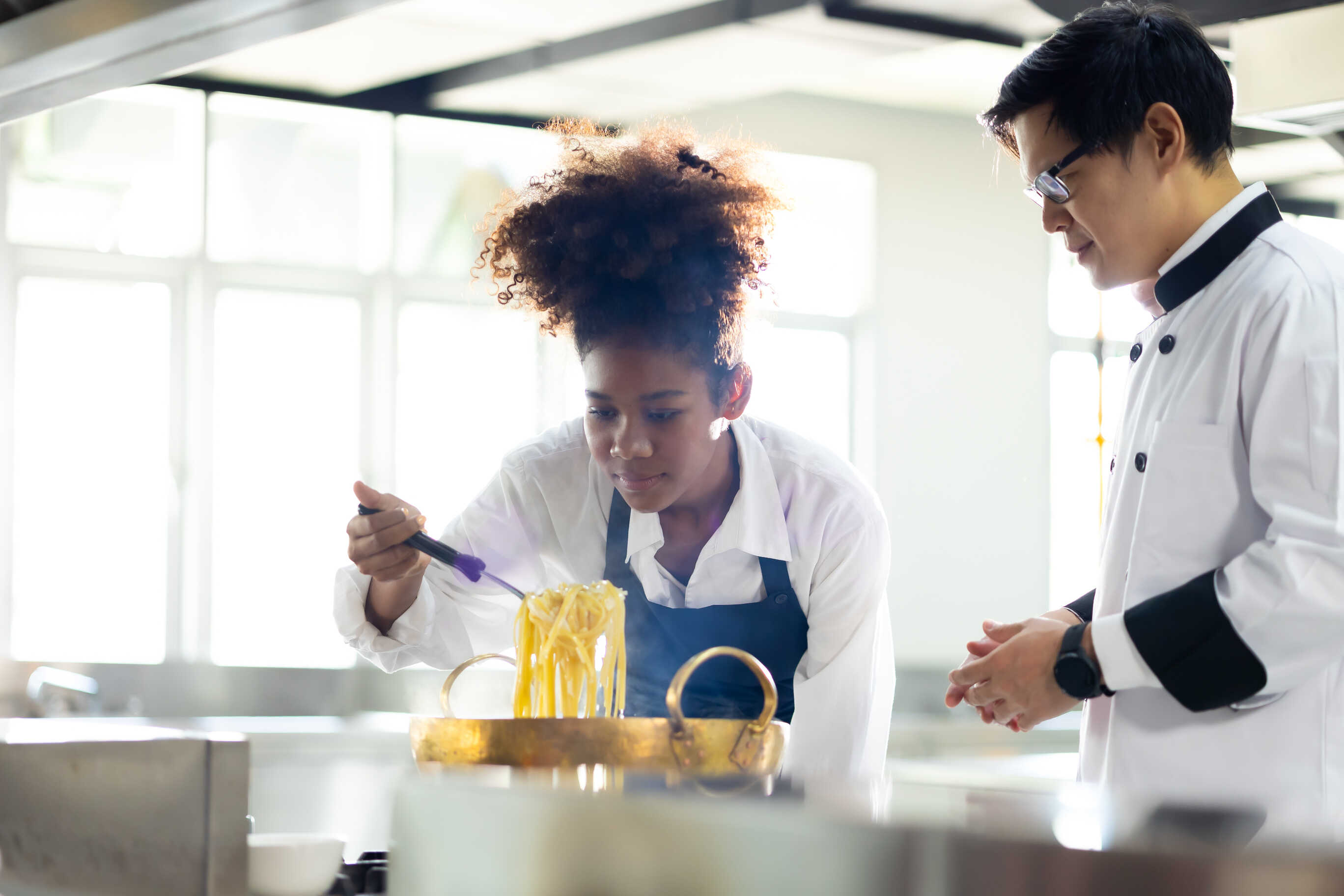 chef training student in kitchen